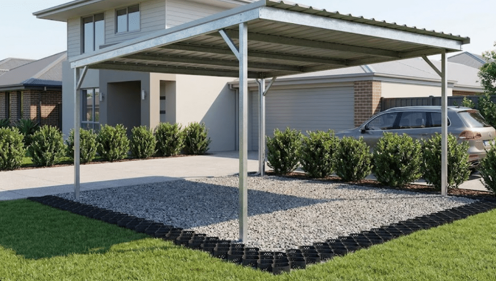 Metal carport installed over a BaseCore HD carport grid base with crushed stone infill, residential backyard.